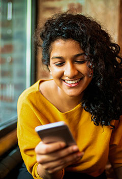 Young lady using her smartphone in a restaurant