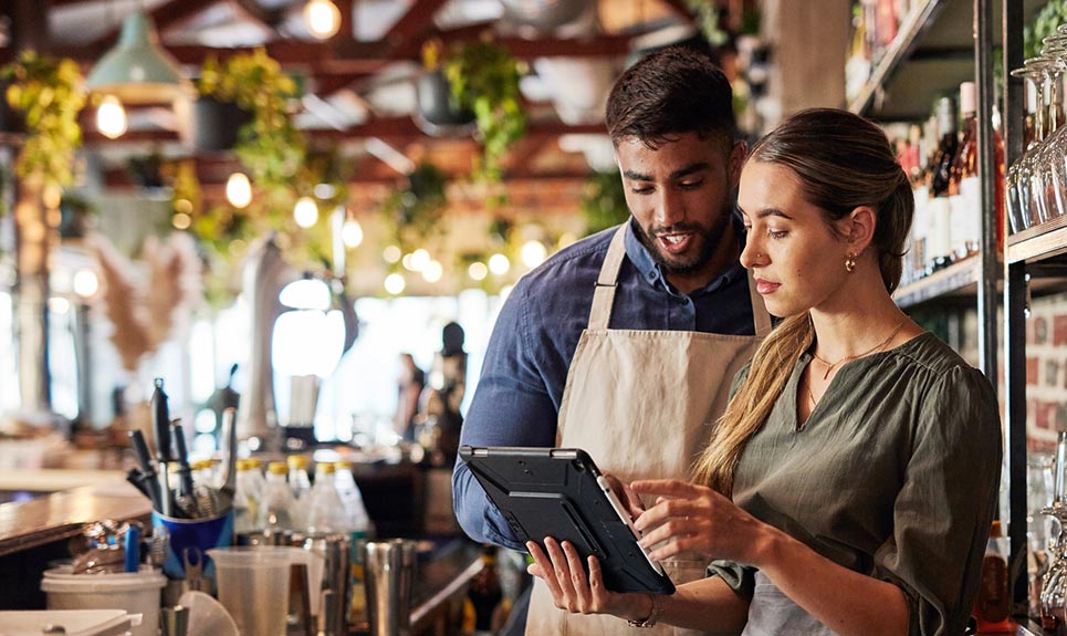 Coworkers looking at a smart tablet in a restaurant