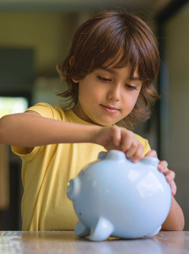 Little boy taking money out of his piggy bank savings