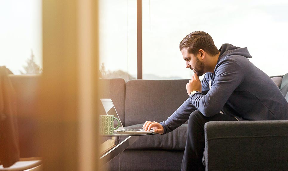 Man using a laptop computer in his living room