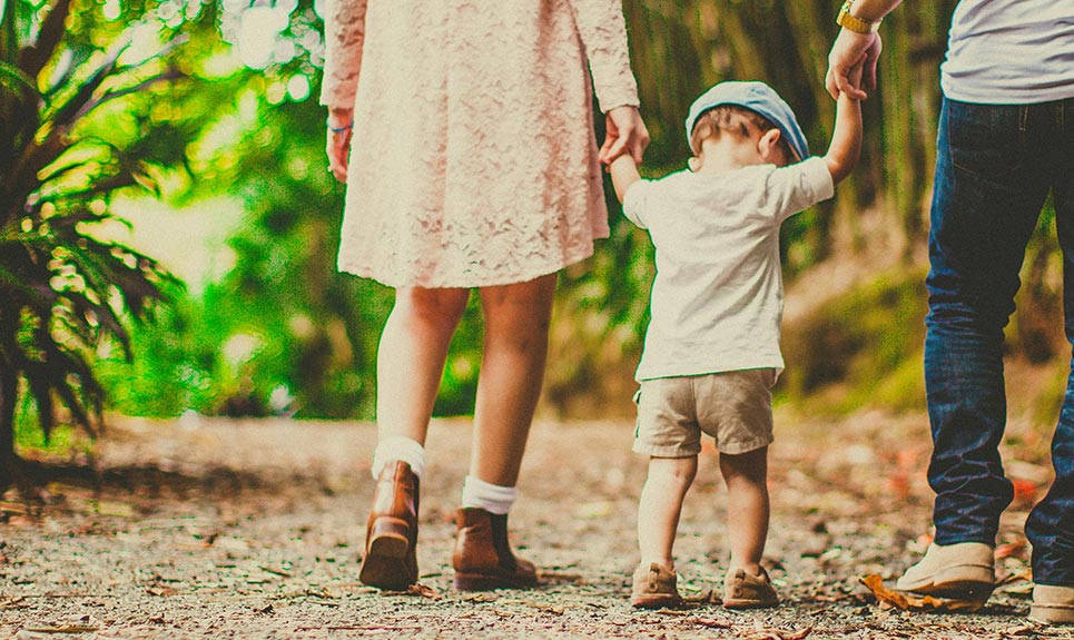 A young family walking along a trail